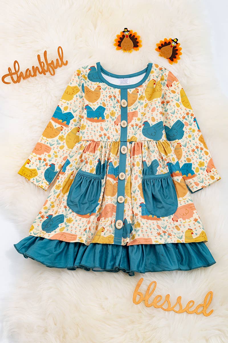 HEN PRINTED DRESS WITH TEAL POCKETS & RUFFLE HEM. LOI: L